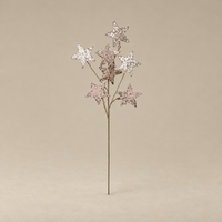 A single artificial starburst flower stem with five glittery metallic star tips in silver, rose gold, and bronze tones, set against a solid beige background.