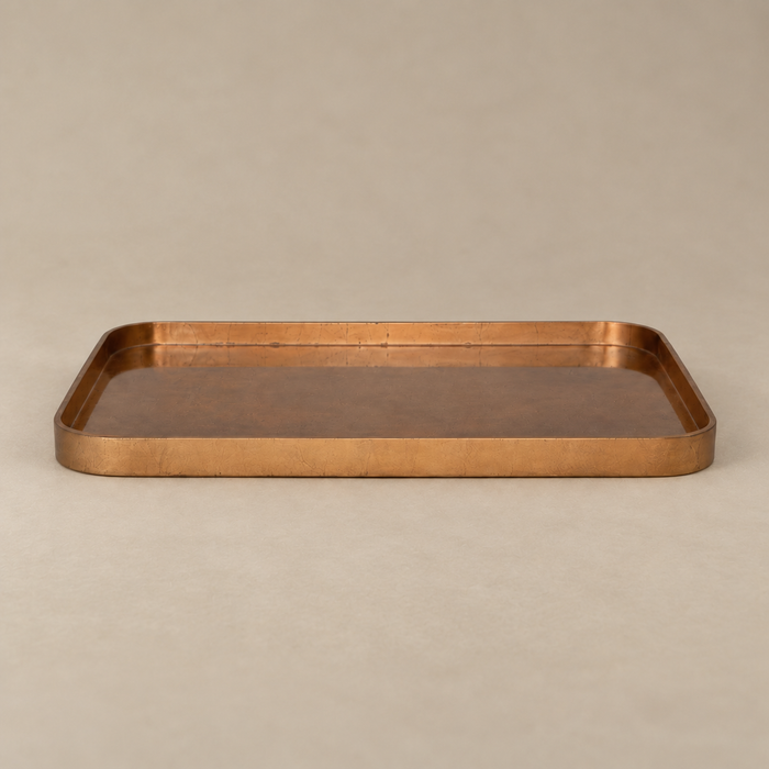 A rectangular copper tray with a hammered texture and raised rim, shown on a neutral beige background.