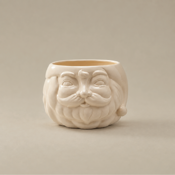 A cream-colored ceramic planter shaped like a stylized face with a beard and mustache, set against a solid beige background.