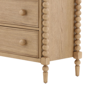 Wooden dresser with spindle legs on a white background